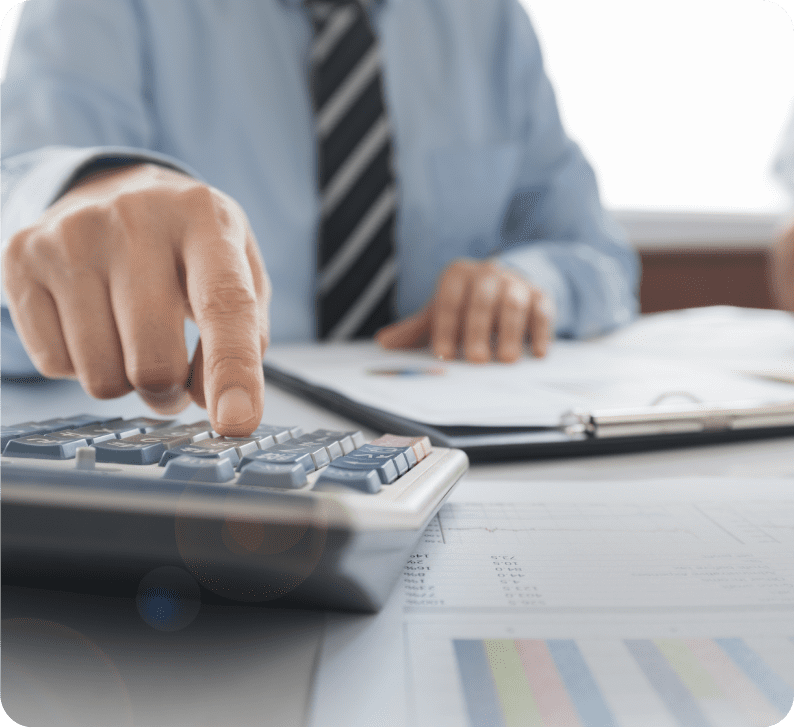 Businessman using a calculator with financial documents and reports